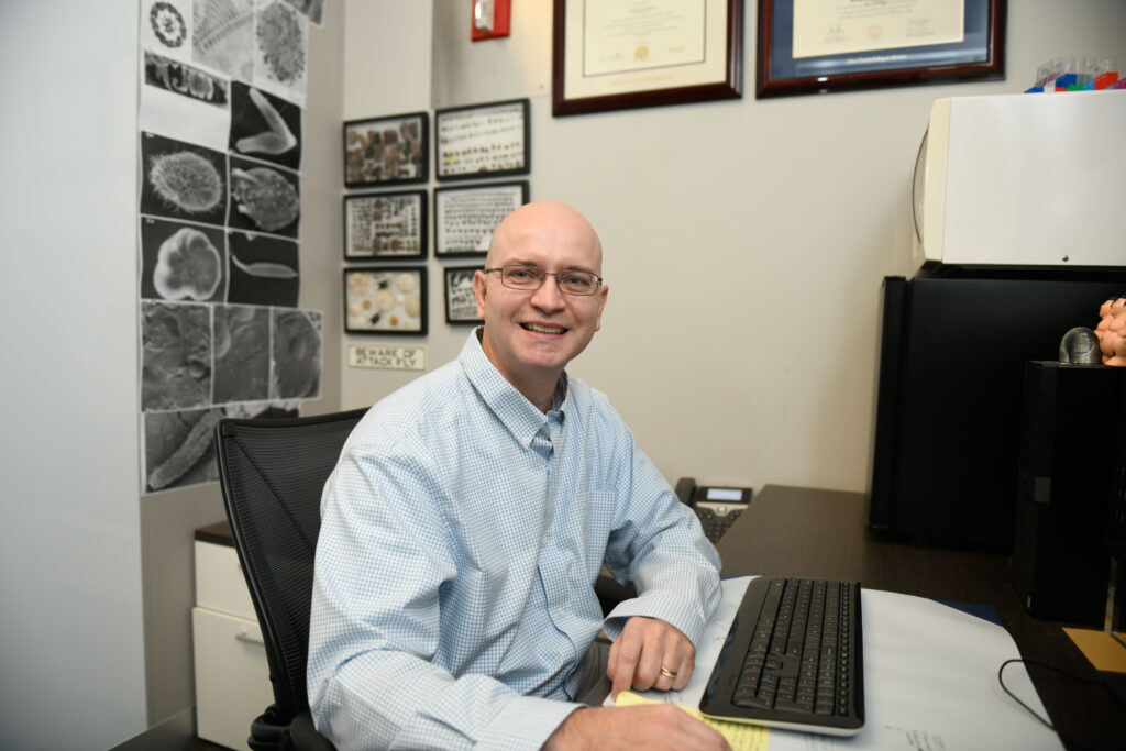 Dr. Aaron Bell at desk. 